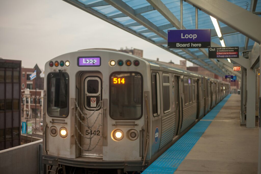 A silver train pulling into a train station